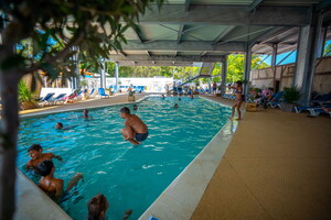 Enfants jouant dans la piscine couverte du parc aquatique du camping 5 étoiles Le Vieux Port dans les Landes