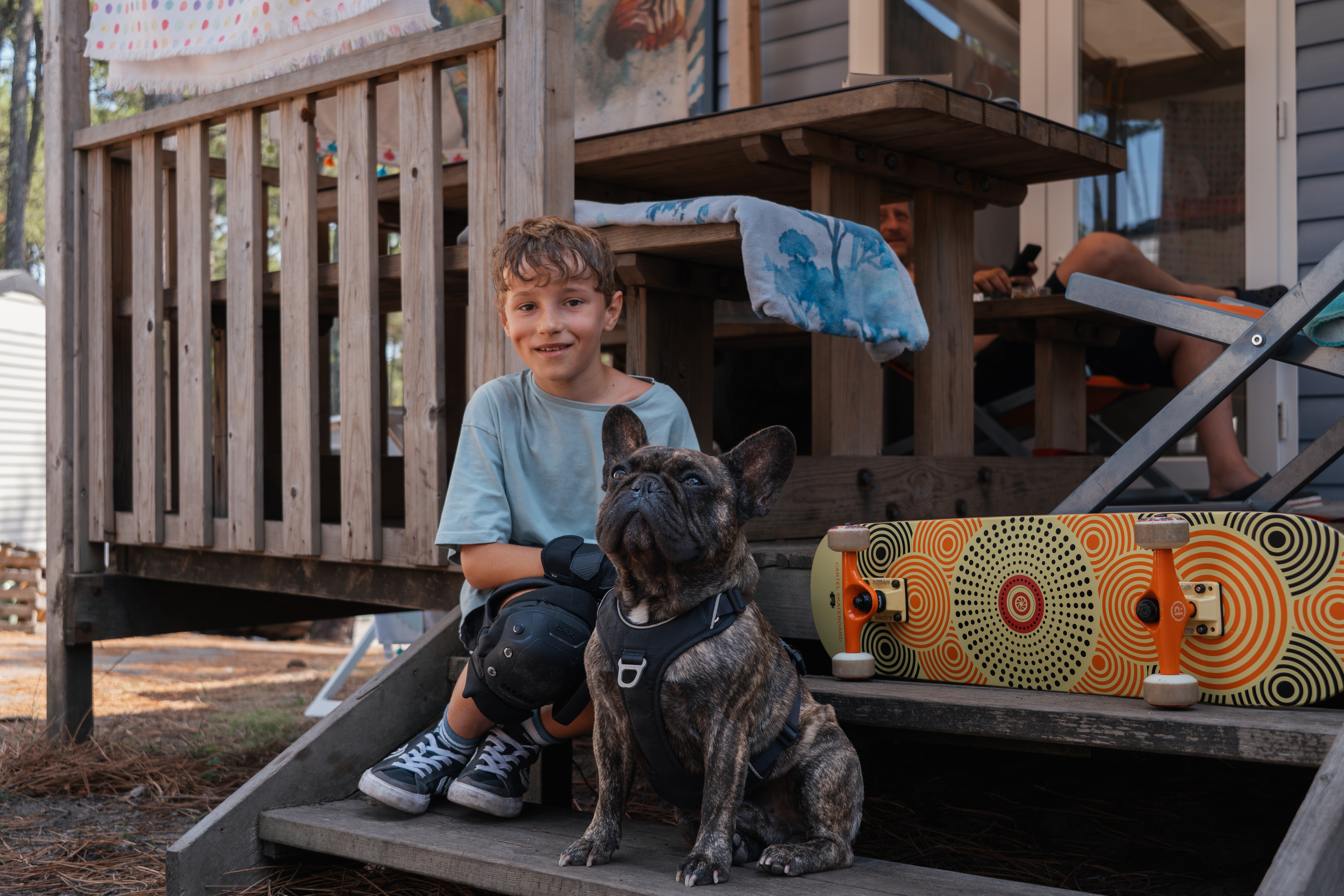 Photo campeur avec petit chien blanc vacances à la plage : balade nature camping Landes, sentier sable océan lisière forêt pinède, compagnon fidèle détente plein air Messanges.