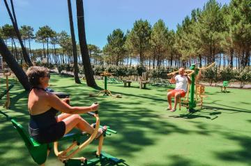 VP-camping-aire-fitness-plein-air-5-etoiles-entre-dune-foret-plage-ocean-atlantique-remise-forme-espace-secure-musculation-physique-cardio-couple-homme-femme-par temps ensoleillé dans les landes derrière la dune en bord de mer