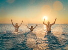 famille heureuse dans l'océan au sunset en train de jeter de l'eau avec paillette pour les fêtes de fin d'année 2024 et annoncer 2025 Le Vieux Port article 2025 Découvrez la Wishlist la nouvelle fonctionnalité du camping 5 Le Vieux Port La magie des vacances de Noël et des fête de fin d'année sauvegarder séjour camping
