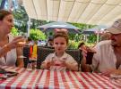 Demi-pension-services-camping-5-etoiles-vieux-port-landes-restaurant-terrasse-couple-avec-enfant-qui-trinquent-aux-vacances