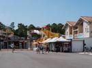 Commerces-services-camping-5-etoiles-vieux-port-landes-boutiques-velos-pour-acheter-tous-les-objets-de-plage-et-autres-souvenirs-de-vacances-dans-les-landes-en-bord-de-mer-avec-des-jeunes-personnes-qui-marchent-sur-la-place-du-village-vers-leur-location-de-vélos