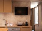 Photo d'une télévision écran plat moderne installée dans le salon du mobil home Lodge Premium 4 personnes, modèle Taos, situé au camping Le Vieux Port à Messanges. La télévision est fixée au mur face à un canapé confortablement aménagé, avec une décoration chaleureuse et lumineuse dans un espace convivial. La pièce dispose également d'éléments de mobilier en bois clair, d'une grande fenêtre laissant entrer la lumière naturelle, et d'accessoires modernes pour un séjour agréable en famille ou entre amis