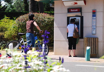 Distributeur automatique de billets à l'entrée du camping 5 étoiles Le Vieux Port dans les Landes
