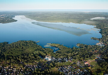 Rives du lac de Soustons dans les Landes avec l'océan Atlantique en arrière-plan