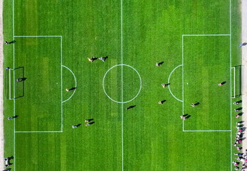 Camping avec terrain de football dans les Landes (1) vue drone du dessous d'un terrain de foot sur gazon avec personnes disputant un match