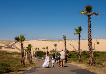 Camping avec accès direct à la plage en bord de mer : famille se rendant à l'océan à pied avec poussette par une belle journée d'été
