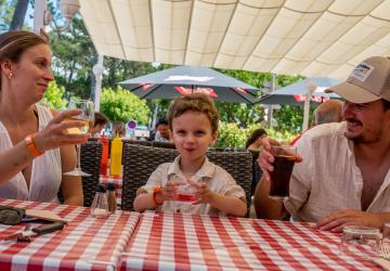Demi-pension-services-camping-5-etoiles-vieux-port-landes-restaurant-terrasse-couple-avec-enfant-qui-trinquent-aux-vacances
