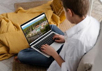Wifi-camping-5-etoiles-vieux-port-landes-ordinateur-portable-telephone-un-enfant-regarde-prochaines-vacances-de-rêve-au-grand-parc-aquatique-bord-de-plage