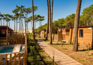 tous-nos-hebergements-campings-5-etoiles-vieux-port-landes-quartier-premium-2025_MAJ_SITE_HEBERGEMENTS-vue-sur-dune-ciel-bleu-piscine-premium-quartier-pinède-pins-nature-sauvage-sable-landes-40-messanges-barrière-bois-maisons-mobil-homes-eco