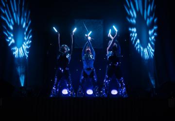 lumières noires bleues et violettes avec instruments LEDs et flash des spots pour mettre en valeur les danses iconiques des 3 performeurs 