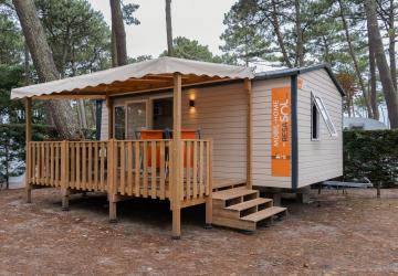 Terrasse ensoleillée avec mobilier de jardin devant un mobil home dans un camping en bord de mer dans les Landes