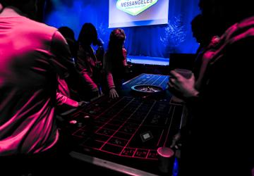 Soirée casino organisée lors d’un séminaire à Messanges, dans le camping Le Vieux Port et la salle Arena, avec tables de jeu, roulette, jetons et participants en tenue de soirée profitant d’une ambiance festive et élégante, éclairée par des jeux de lumière modernes et un décor événementiel professionnel.