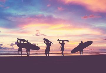 Surfeur dans le coucher de soleil