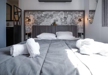 OTELLO intérieur 2 chambres _ lit double avec rayon de soleil sur la couette de cette pièce parentale avec salle de bain privée