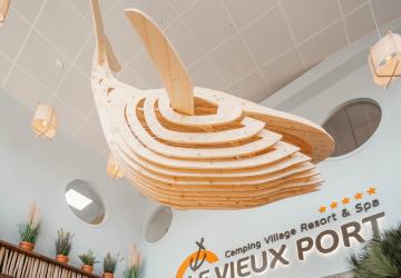 Photo nouvelle réception camping 2026 : accueil repensé thème naval, énorme baleine en bois au plafond, fluidité des arrivées, ambiance port de mer et décor marin chaleureux.