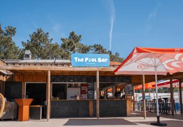 Photo comptoir face The Pool Bar parc aquatique : bar central splash piscine burgers frites glaces cocktails, service restauration aquatique famille, ambiance conviviale bassin toboggans.