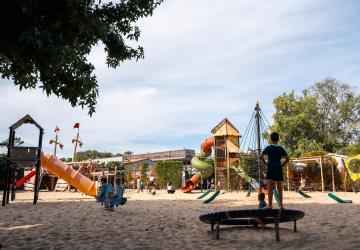 Enfants de 6 à 12 ans jouant sur l’aire de jeux en sable du camping Le Vieux Port, encadrés par les animatrices du mini-club