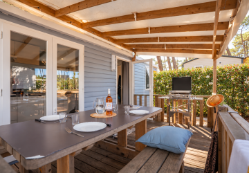 Table dressée sur la terrasse extérieure du mobil-home Resasol 4/6 personnes, aménagée pour les repas en plein air pendant les vacances au camping Le Vieux Port.