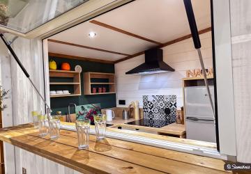 Terrasse du futur Chalet Écume représentée en modélisation 3D non contractuelle, , nouvelle location pour quatre personnes, avec bar comptoir blanc élégant pour les soirées d'été ou de printemps en séjour vacances bord de mer
