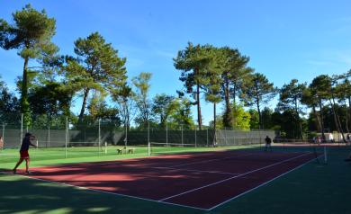 Match sur un des courts de tennis du camping 5 étoiles Le Vieux Port dans les Landes