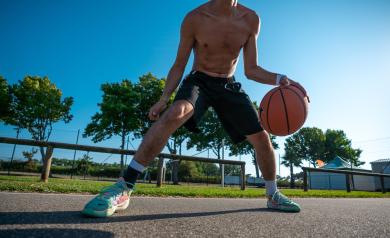 Joueur de basket sur le terrain de sports du camping 5 étoiles Le Vieux Port dans les Landes