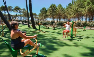 VP-camping-aire-fitness-plein-air-5-etoiles-entre-dune-foret-plage-ocean-atlantique-remise-forme-espace-secure-musculation-physique-cardio-couple-homme-femme-par temps ensoleillé dans les landes derrière la dune en bord de mer