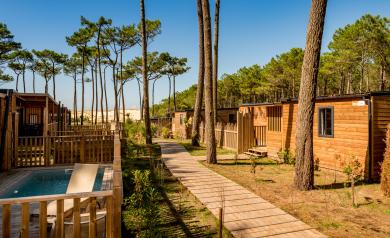 tous-nos-hebergements-campings-5-etoiles-vieux-port-landes-quartier-premium-2025_MAJ_SITE_HEBERGEMENTS-vue-sur-dune-ciel-bleu-piscine-premium-quartier-pinède-pins-nature-sauvage-sable-landes-40-messanges-barrière-bois-maisons-mobil-homes-eco