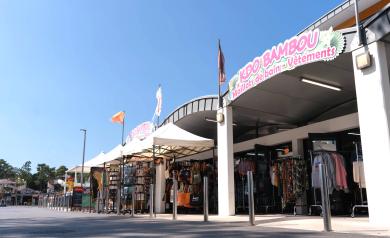 Commerces du camping Le Vieux Port dans les Landes, avec supermarché SPAR proposant alimentation, baguettes et viennoiseries artisanales, librairie-presse, boutiques d’articles de plage et souvenirs, ainsi que snacks et bars à côté du parc aquatique, offrant tout le nécessaire à proximité immédiate des hébergements en bord de mer.