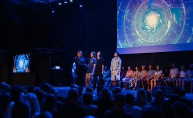 Spectacle d’hypnose et de mentalisme à l’Arena du camping Le Vieux Port, avec Magic Chaz sur scène, hypnotiseur renommé captivant le public dans un show à la fois drôle, bluffant et mystérieux. Les participants, invités sur scène, sont plongés dans un état de conscience modifié, vivant des expériences fascinantes sous des jeux de lumière et une ambiance théâtrale, tandis que le public rit et s’émerveille des phénomènes hypnotiques et des performances de mentalisme orchestrées avec respect et sécurité.