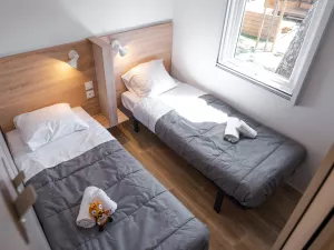 Chambre suite enfant lits jumeaux Lodge Premium jacuzzi 6 personnes avec vue dune dans les Landes au camping Le Vieux Port