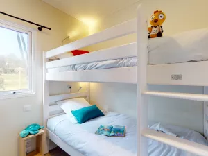 Lit double en hauteur avec la location Cottage Premium Jacuzzi 10 personnes au camping 5 étoiles Le Vieux Port avec Resasol pour vos vacances, loisirs et évenements dans le Sud Ouest de la France au soleil en bord de mer