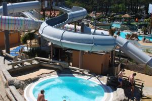 Camping avec bassin balnéo et jacuzzi dans les Landes vue du spa vers le toboggan et la pinède de pins de la forêt avoisinante