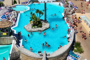 Camping avec piscines chauffées dans les Landes Piscine pour baignade et détente ambiances paradisiaques au bord de l’eau grand bassin, avec îlot décoré de palmiers, et jacuzzi sur la plage est une invitation au farniente