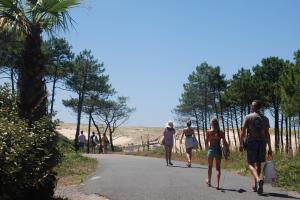 Vacanciers se rendant à la plage en traversant la dune par le chemin d'accès direct depuis le camping