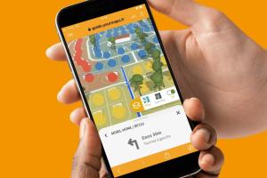 couple tenant dans leurs mains un téléphone mobile avec le guidage interactif de l'application RESASOL ouvert pour pouvoir se repérer dans le camping pendant leur séjour