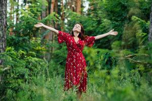 se connecter à la nature est bon pour la santé mentale l'eco thérapie pour avoir un impact bénéfique sur le corps et l'esprit avec une femme brune en robe rouge qui illustre bien être