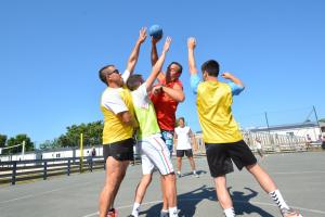 Camping avec City Stade dans les Landes en bord de mer (2) 4 handballistes avec arbitre animateur en train de prendre de l'élan pour lancer la balle dans la cage sur terrain en béton avec plots
