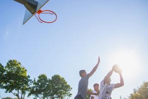 Camping avec terrain de basket dans les Landes en bord de mer Enfants jouant au basket sous le soleil au camping