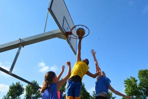 Camping avec terrain de basket dans les Landes en bord de mer Joueur faisant un saut pour un dunk spectaculaire au camping