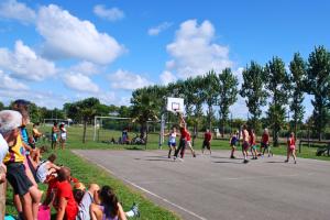 Camping avec terrain de basket dans les Landes en bord de mer Personnes souriantes jouant au basket au camping en plein air