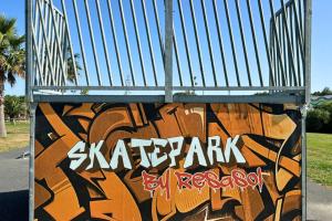 Skatepark moderne avec rampes et rails dans un camping en pleine nature, Espace de pratique du skate dans le camping avec zones de sécurité et d'accueil