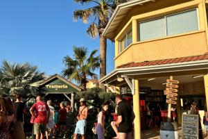 Personnes faisant la queue pour rentrer dans le restaurant pizzeria de la Trattoria au camping par une belle journée ensoleillée avec leur pension complète en formule optionnelle
