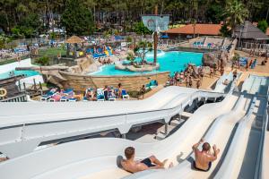 2 campeurs glissent sur les toboggans du grand parc aquatique du camping 