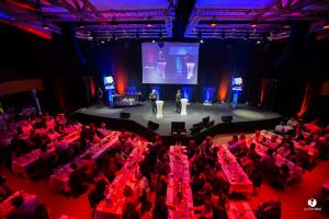 arena dîner cabaret avec présentateurs et micro sur la scène en présence de convives