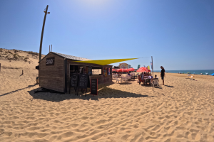 gopro snack de la plage avec ses chaises et tables blanches en plastique et ses parasols rouges miko pour trouver tout ce qu'il faut lors de votre pause au soleil sans trop vous éloigner de l'océan