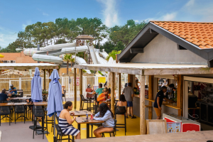 bars, tables et chaises hautes avec barrières vitrées qui permettent de regarder ce qu'il se passe dans le parc aquatique avec les descentes en toboggans des usagers
