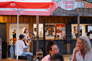 enseigne de pirate visible sur cette photographie avec chanteuse et musicien pour apporter une ambiance unique à ce lieu de rassemlement des bons moments