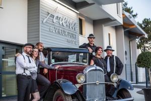Salariés d'une entreprise en train de prendre la pose avec une voiture de collection sur le thème des années 50 devannt la salle de spectacle des Landes -