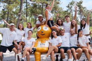Soly avec equip anim VP 2025 au banc du parc aquatique levant les bras par temps ensoleillé